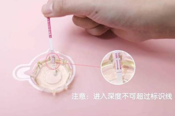 女性取出试纸后将其浸入尿样